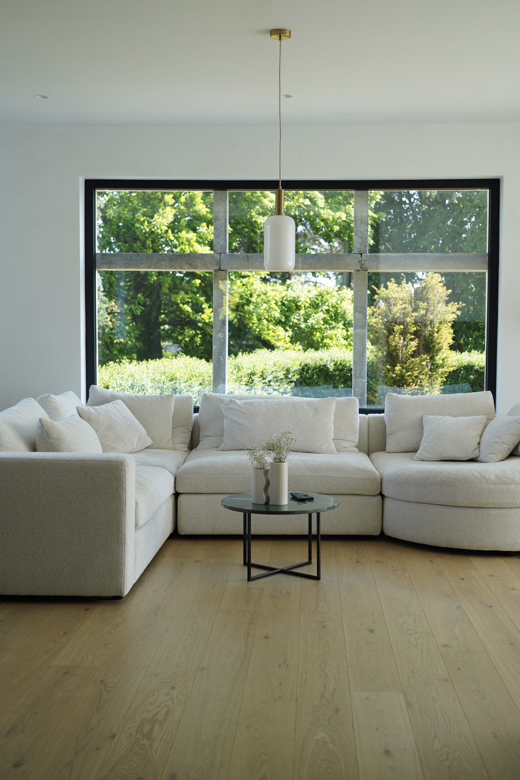 Lichtrijke woonkamer met grote ramen die het buitenlicht binnenlaten en een rustgevende sfeer creëren