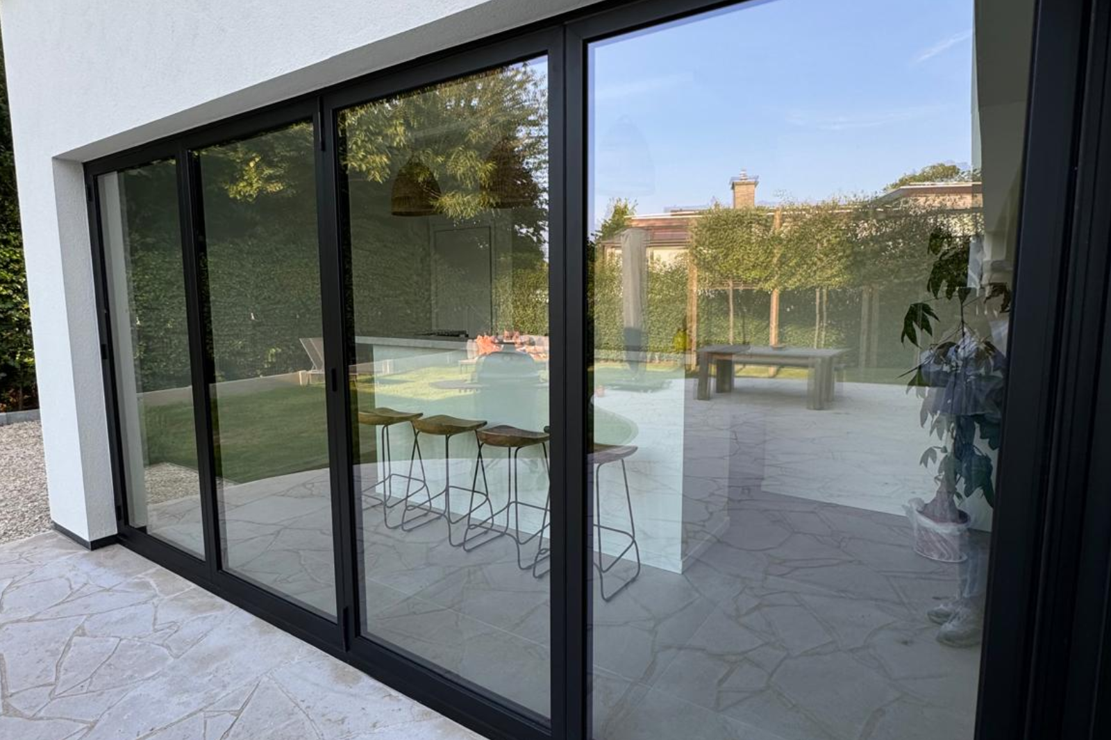 Zwarte aluminium schuiframen met grote glaspartijen.